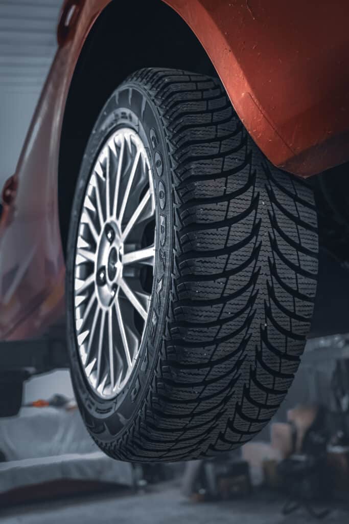 SUV rouge vu de trois quarts, roue au premier plan